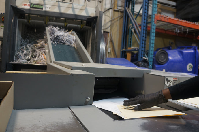 A man shredding confidential documents in an industrial machine
