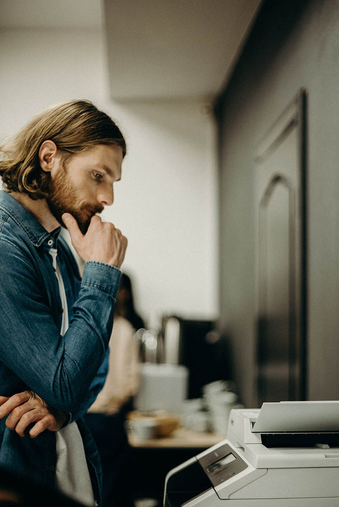 Office worker thinking about the use of a printers